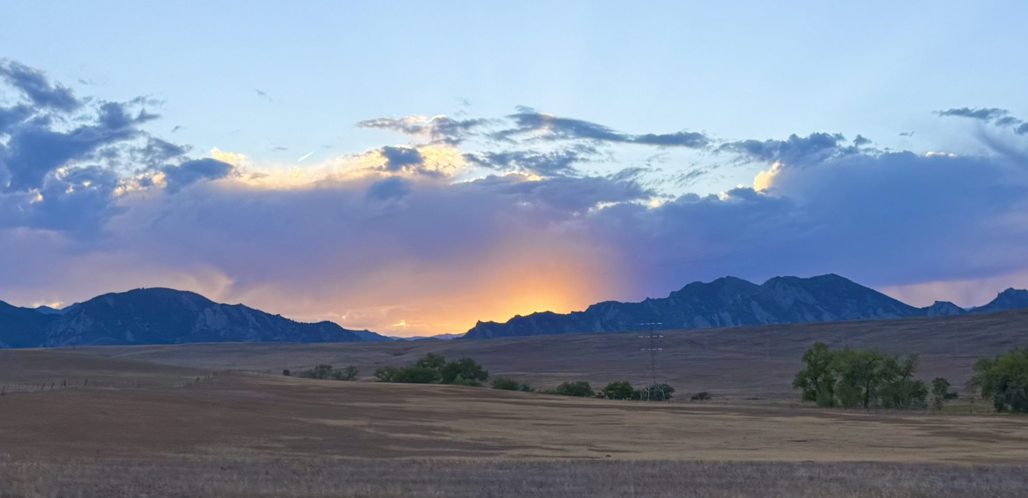 The Flatirons above Boulder at sunset, seen across open prairie