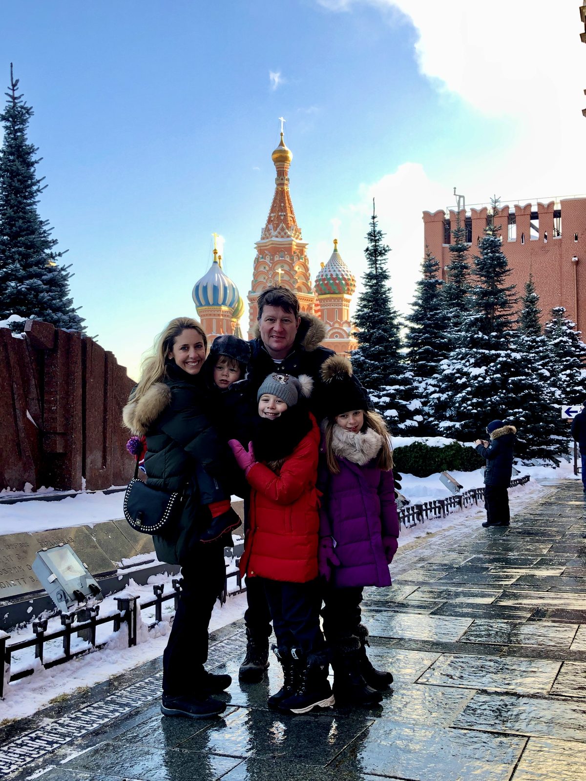 Family in winter coats in front of St Basil's Cathedral, Moscow
